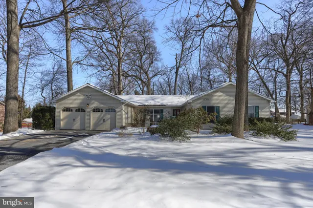 a front view of a house with a yard covered with snow