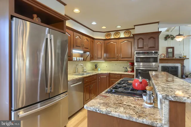 a kitchen with stainless steel appliances granite countertop a stove and cabinets