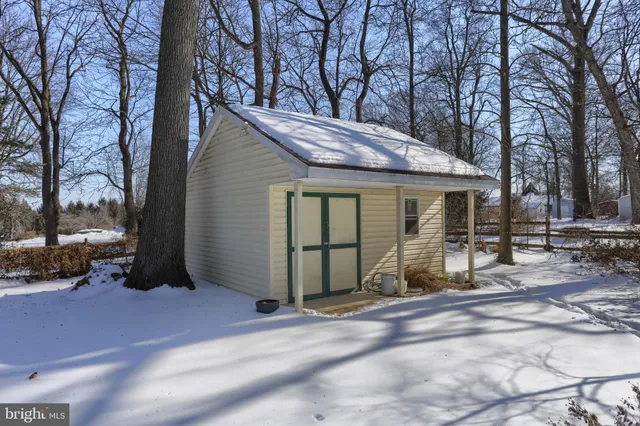 a front view of house with yard and trees in the background