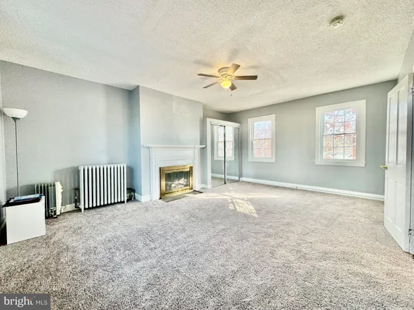 a view of empty room with a fireplace and fan