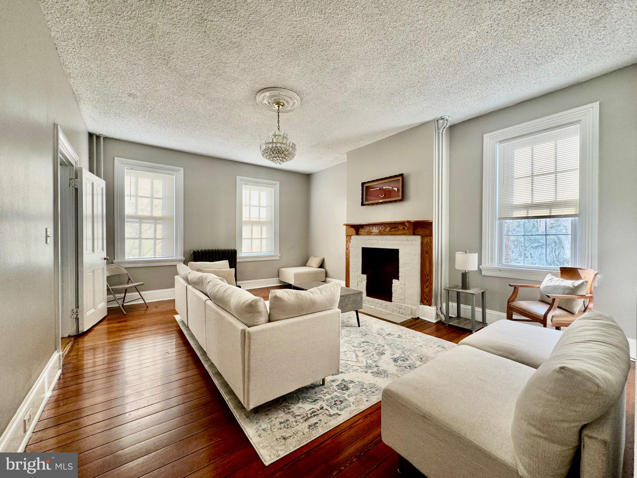 3210 Harford Road Baltimore, MD 21218 - Photo 3 of 33 a living room with furniture a large window and a fireplace