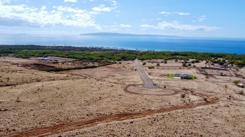 a view of a dry yard with wooden fence