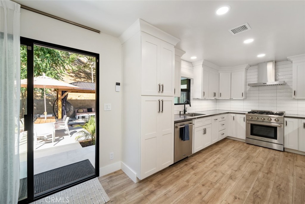 905 Olive Street Paso Robles, CA 93446 - Photo 14 of 61 a kitchen with granite countertop white cabinets and white appliances