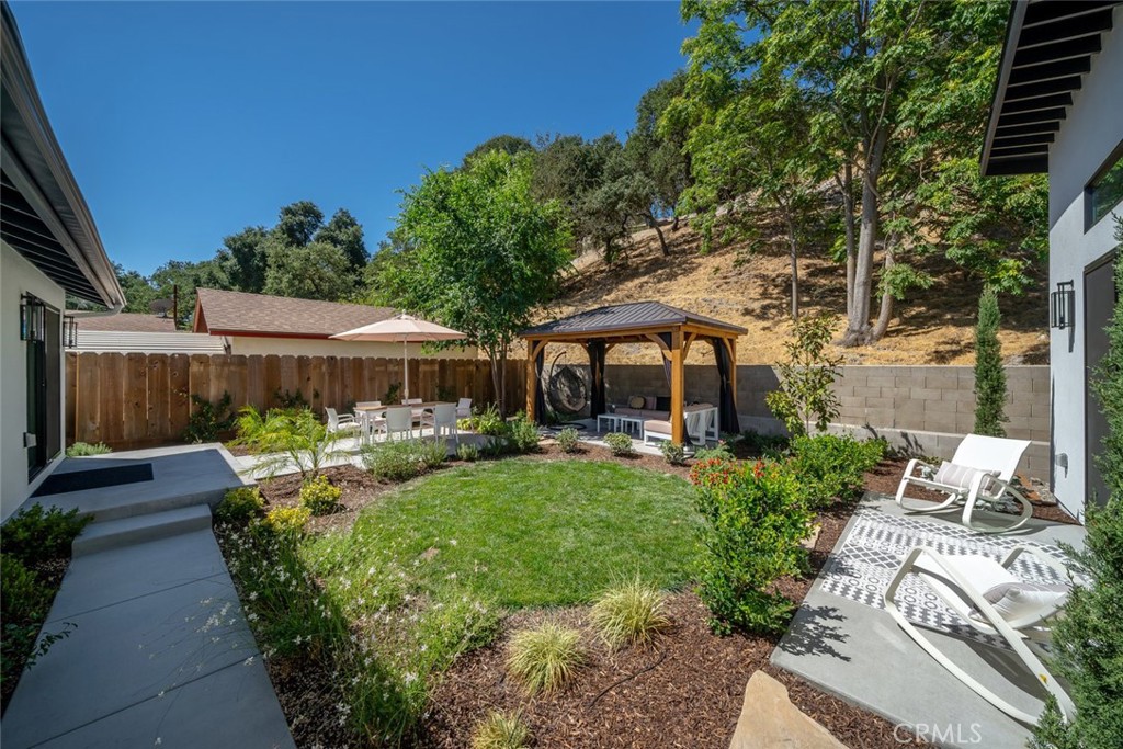 905 Olive Street Paso Robles, CA 93446 - Photo 33 of 61 a view of a patio with table and chairs potted plants with wooden fence