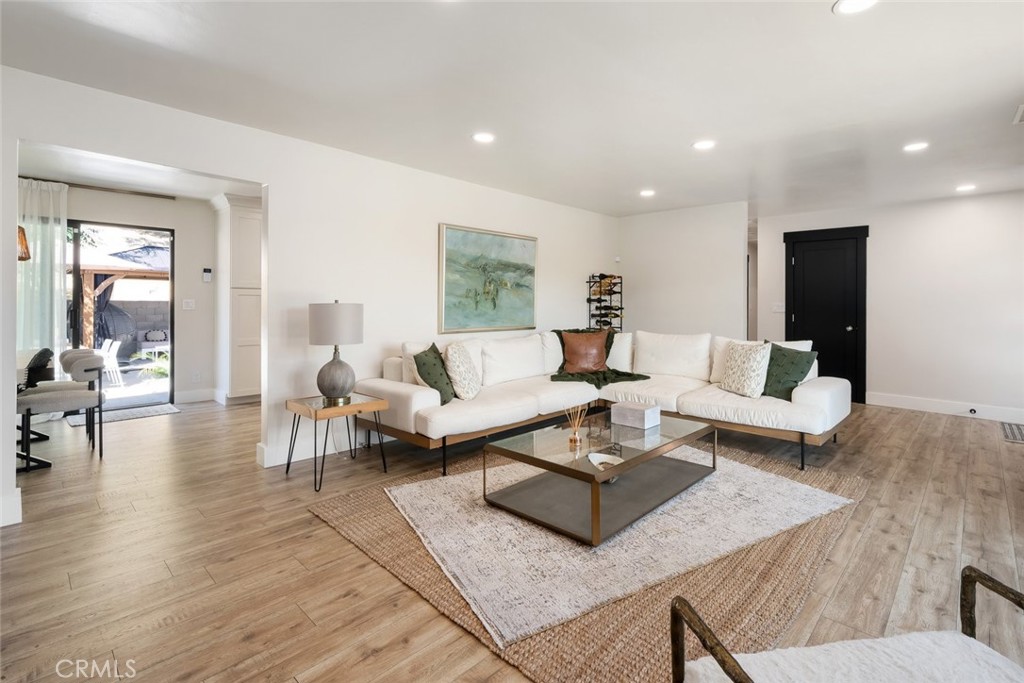 905 Olive Street Paso Robles, CA 93446 - Photo 5 of 61 a living room with couches couches and a dining table with wooden floor