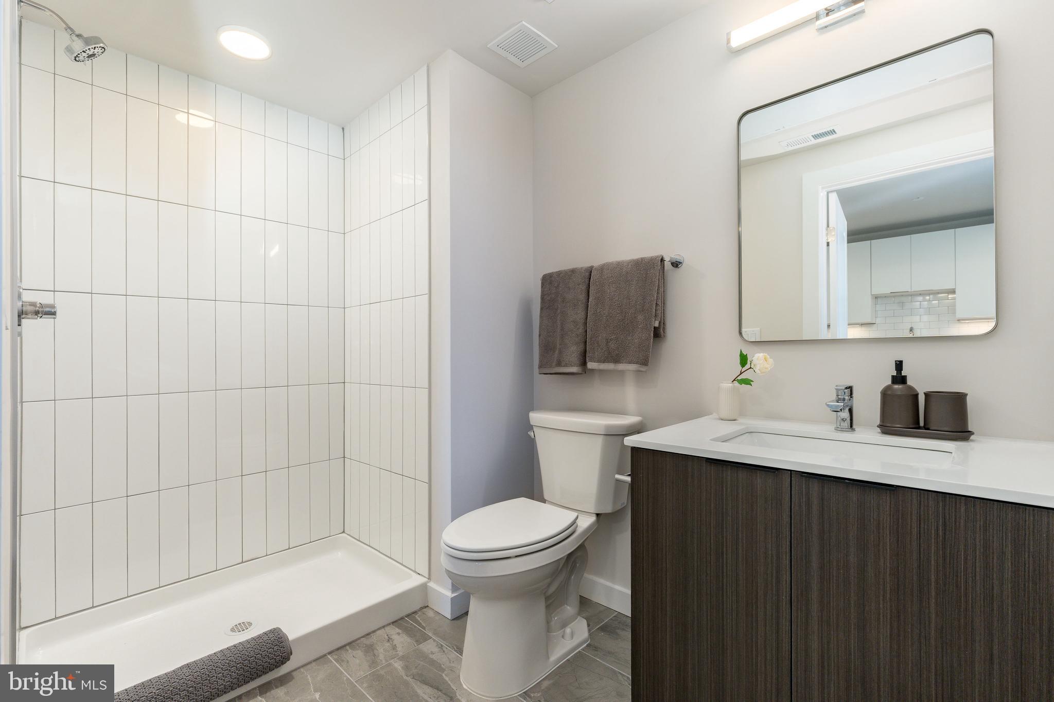 1130 North Delaware Avenue, Unit 307 Philadelphia, PA 19125 - Photo 13 of 30 a bathroom with a toilet a sink a mirror and bathtub
