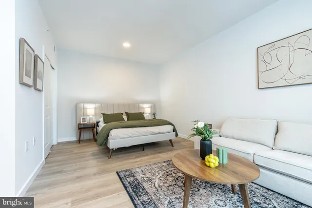 a bedroom with a bed and a refrigerator