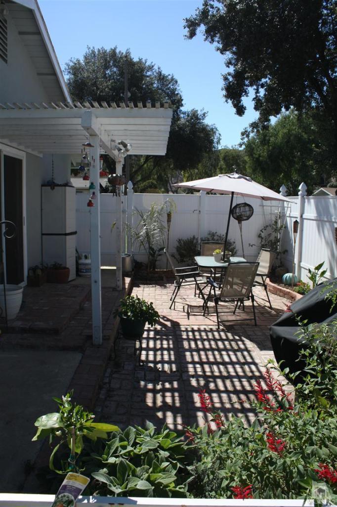 760 Talbert Avenue Simi Valley, CA 93065 - Photo 12 of 12 a view of a patio with table and chairs with potted plants and big trees