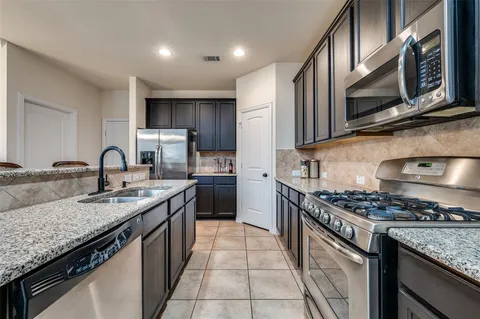 a kitchen with stainless steel appliances granite countertop a sink stove and cabinets