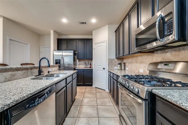 a kitchen with stainless steel appliances granite countertop a sink stove and cabinets