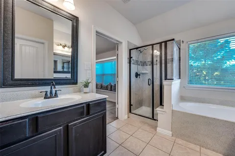 a spacious bathroom with a shower sink and mirror