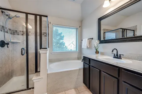 a bathroom with a tub sink and mirror