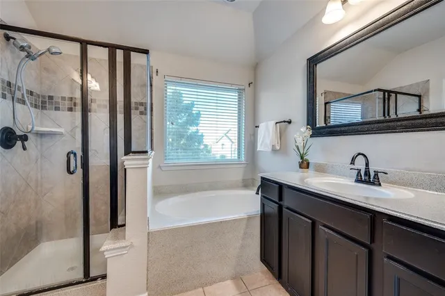 a bathroom with a tub sink and mirror