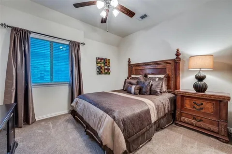 a bedroom with a bed and a lamp on dresser