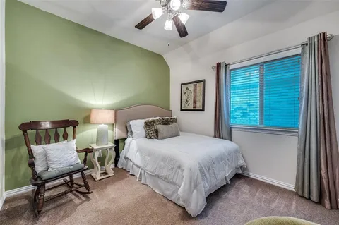 a bedroom with a bed a chair and a large window