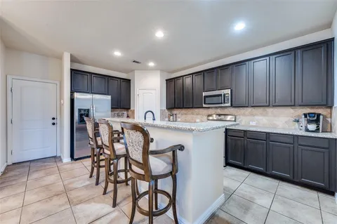 a kitchen with stainless steel appliances granite countertop wooden cabinets a stove top oven a sink and dishwasher