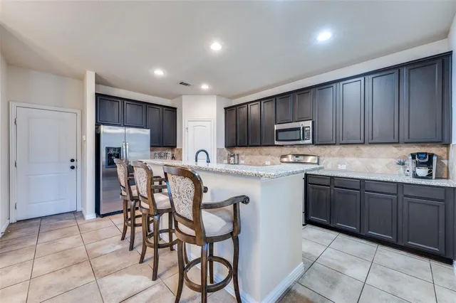 a kitchen with stainless steel appliances granite countertop wooden cabinets a stove top oven a sink and dishwasher