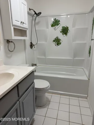 a bathroom with a granite countertop sink a toilet and shower