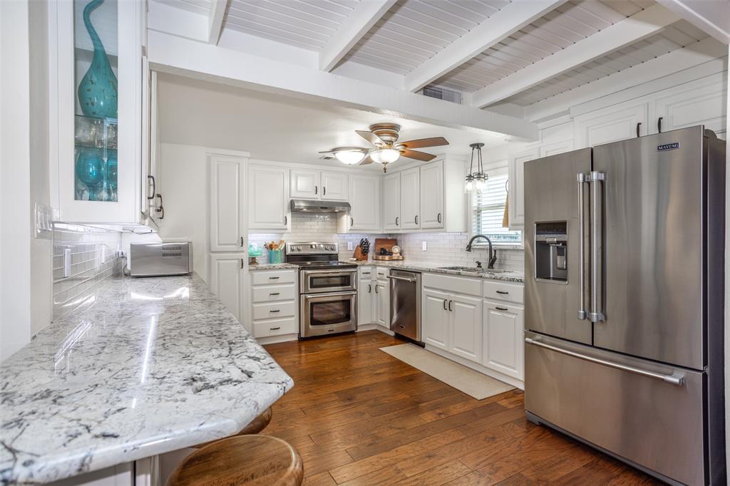 823 Casino Road Nocona, TX 76255 - Photo 12 of 40 a kitchen with stainless steel appliances granite countertop a refrigerator stove microwave and sink