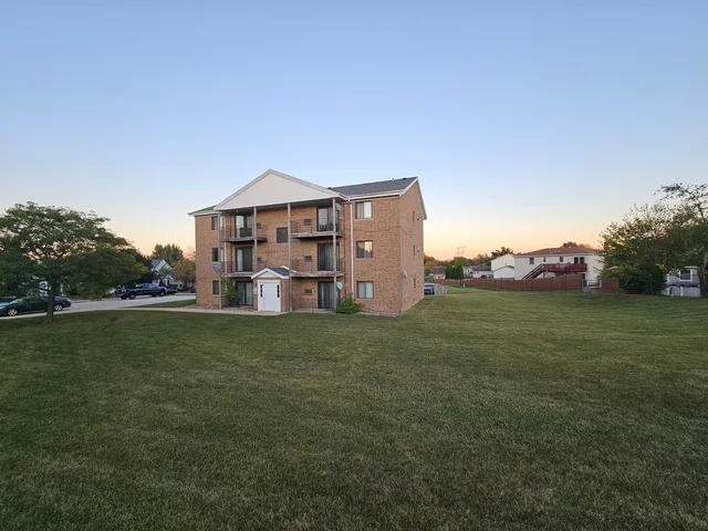 a view of a big house with a big yard and large trees