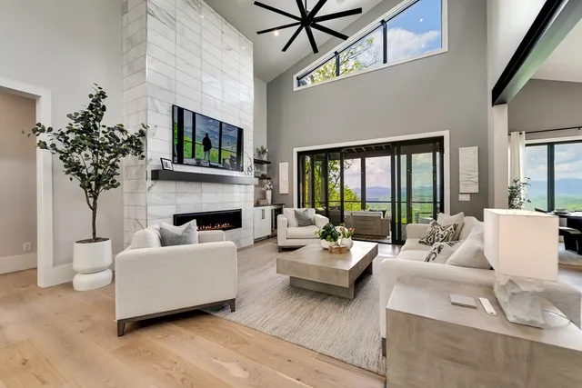 a living room with furniture fireplace and a large window