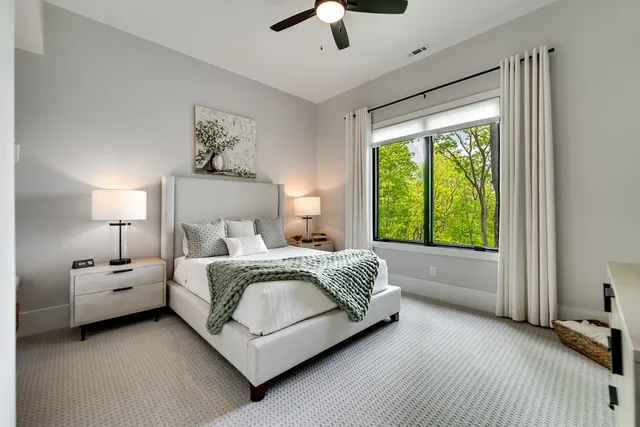 a bed room with a bed and a ceiling fan