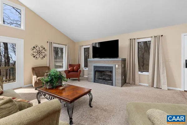 a living room with furniture a flat screen tv and a fireplace