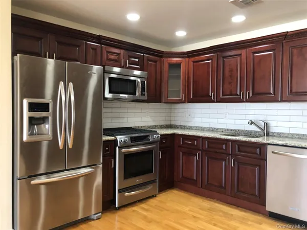a kitchen with stainless steel appliances granite countertop a refrigerator and a sink