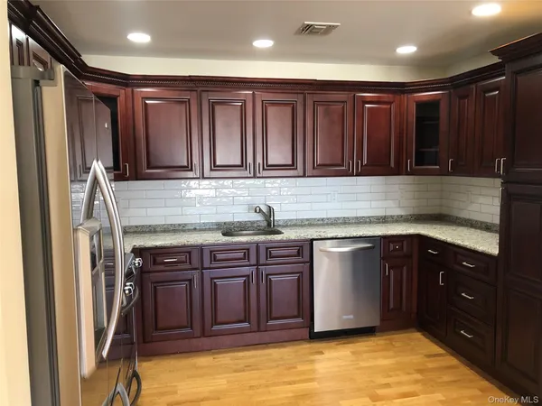 a kitchen with stainless steel appliances granite countertop wooden cabinets a sink and dishwasher