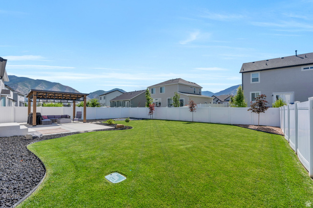 252 North Sunrise Rnch Drive Mapleton, UT 84664 - Photo 9 of 62 Expansive backyard featuring a large green lawn, concrete patio, and a wood pergola with a metal roof
