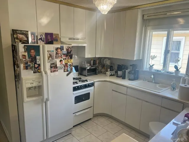 a kitchen with a sink a refrigerator and cabinets