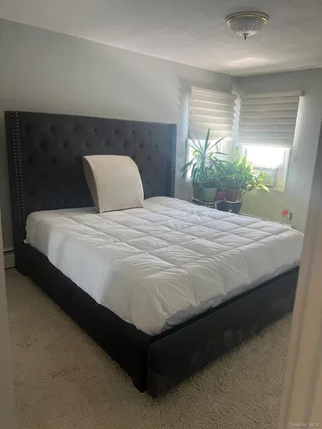 a large bed sitting in a bedroom next to a window