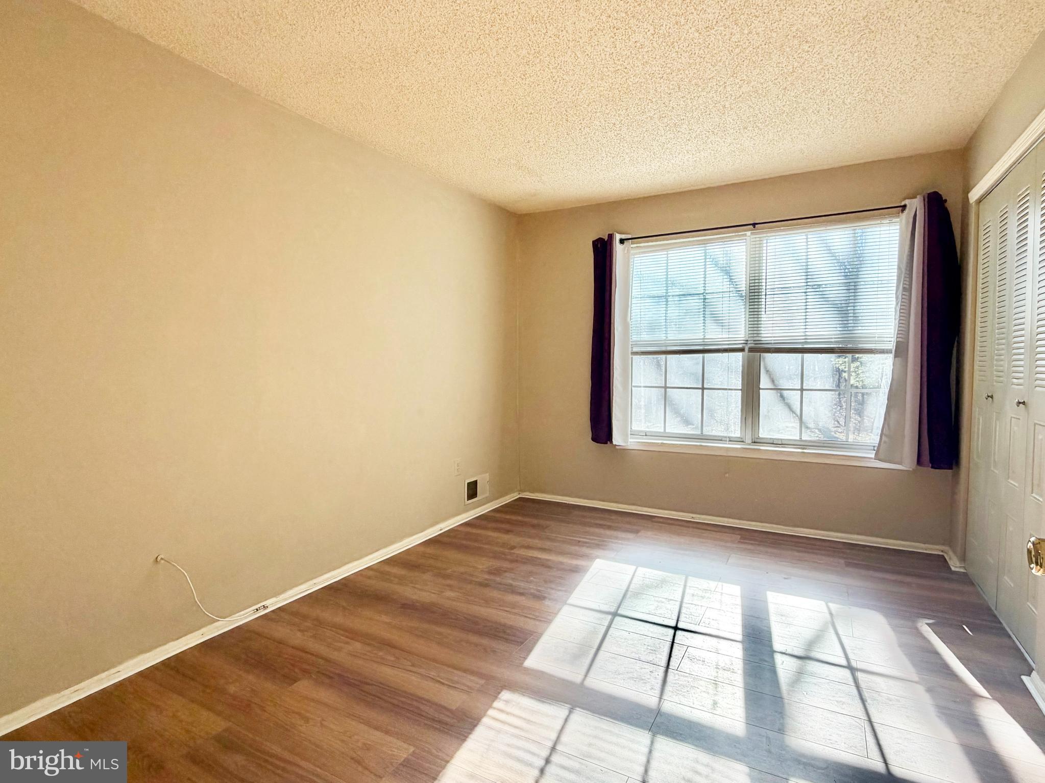 82 Versailles Court Hamilton, NJ 08619 - Photo 9 of 16 wooden floor in an empty room with a window