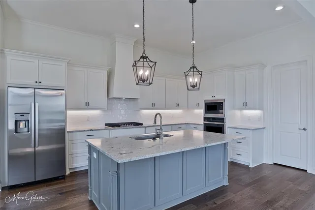 a kitchen with kitchen island a counter space a sink and appliances