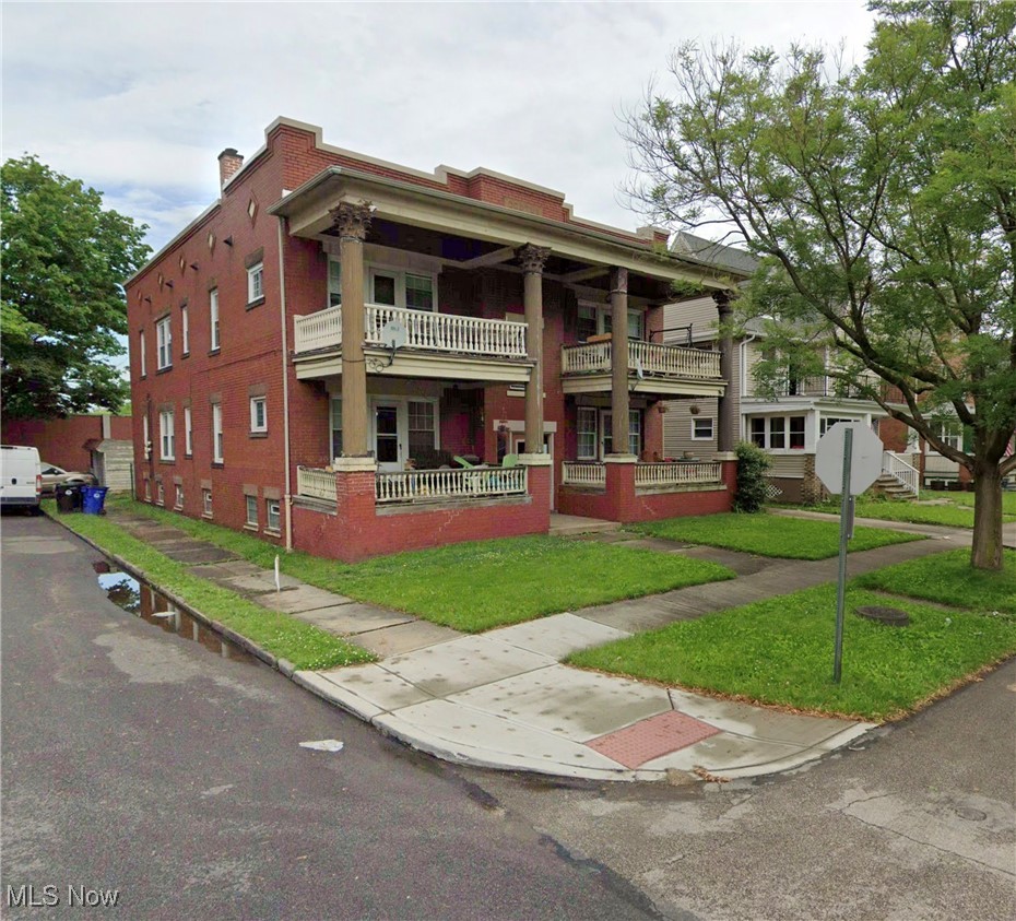 3820 Riverside Avenue Cleveland, OH 44109 - Photo 1 of 1 Neoclassical home featuring covered porch, brick siding, a front lawn, and a chimney