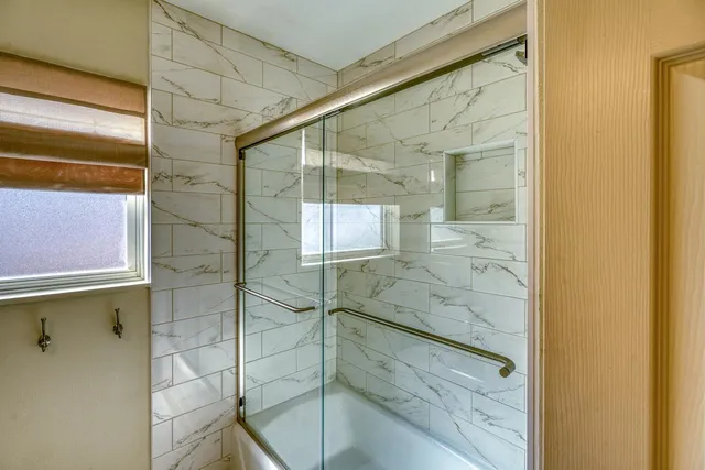 a bedroom with a bed and glass door