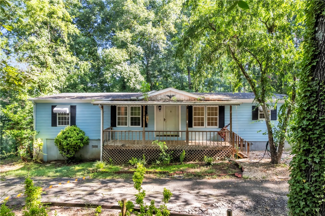 178 Childress Road Pickens, SC 29671 - Photo 1 of 32 A charming blue-sided home sits nestled among verdant trees, offering a peaceful retreat with a welcoming front porch.