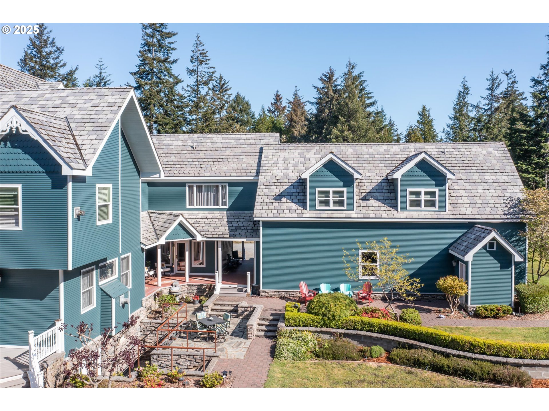 54983 Morrison Road Bandon, OR 97411 - Photo 2 of 29 a view of house with garden and tall trees