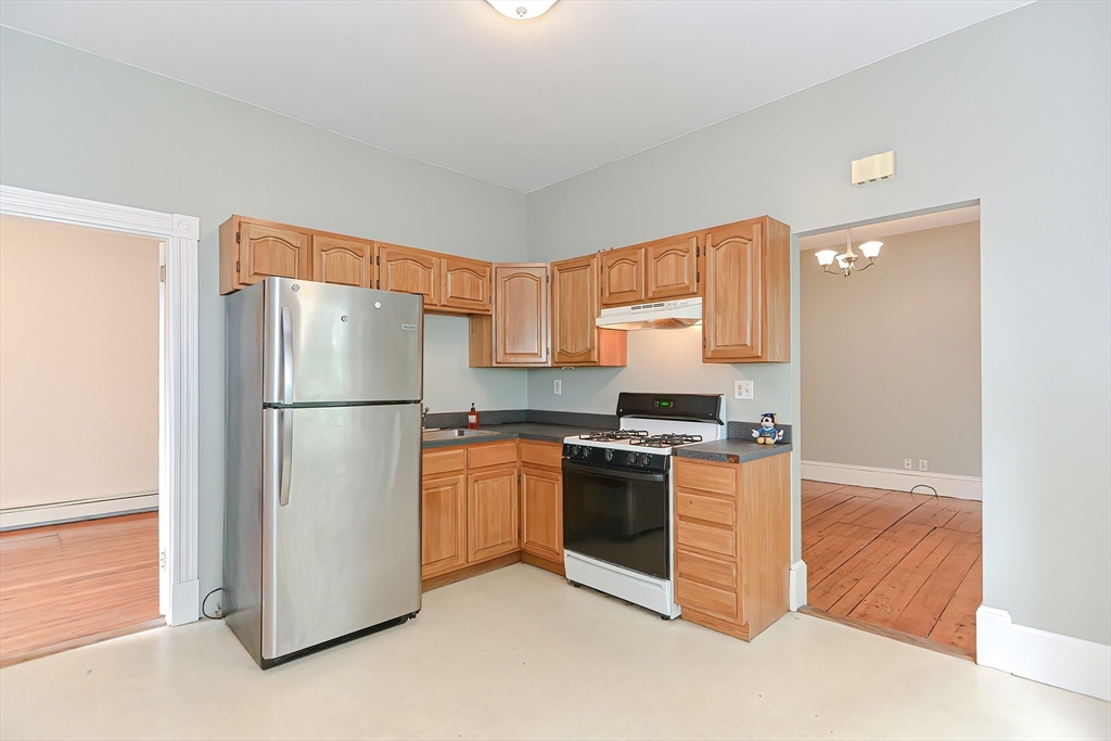 a kitchen with stainless steel appliances granite countertop a refrigerator a stove a sink and a more cabinets