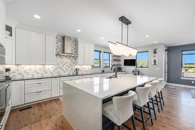 a large kitchen with kitchen island a dining table and chairs