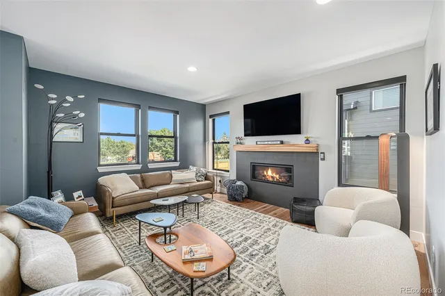 a living room with furniture a fireplace and a flat screen tv