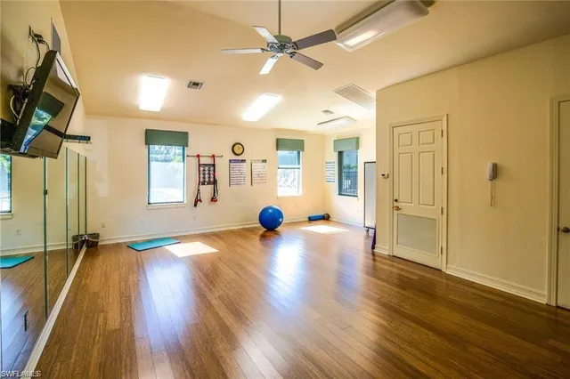 a view of a livingroom with wooden floor and a ceiling fan
