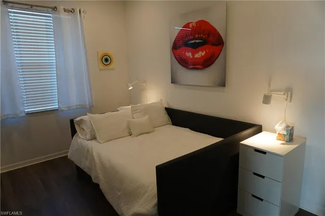 a bedroom with a bed and a painting on the wall