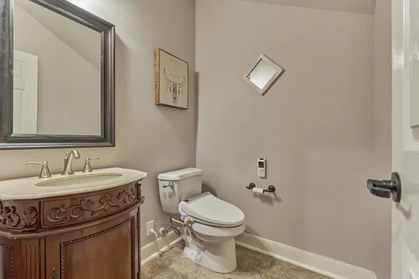 a bathroom with a toilet a sink and mirror