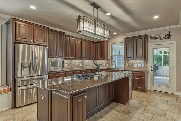 a kitchen with stainless steel appliances granite countertop a stove a refrigerator and a sink