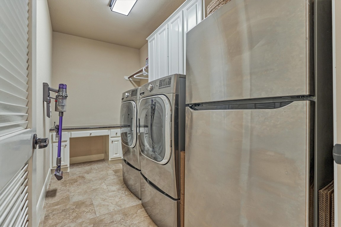 6615 Pelham Chase Drive Spring, TX 77389 - Photo 21 of 49 The laundry room is located on the first floor with a desk area, storage cabinets, hanging rod and space for a second refrigerator!