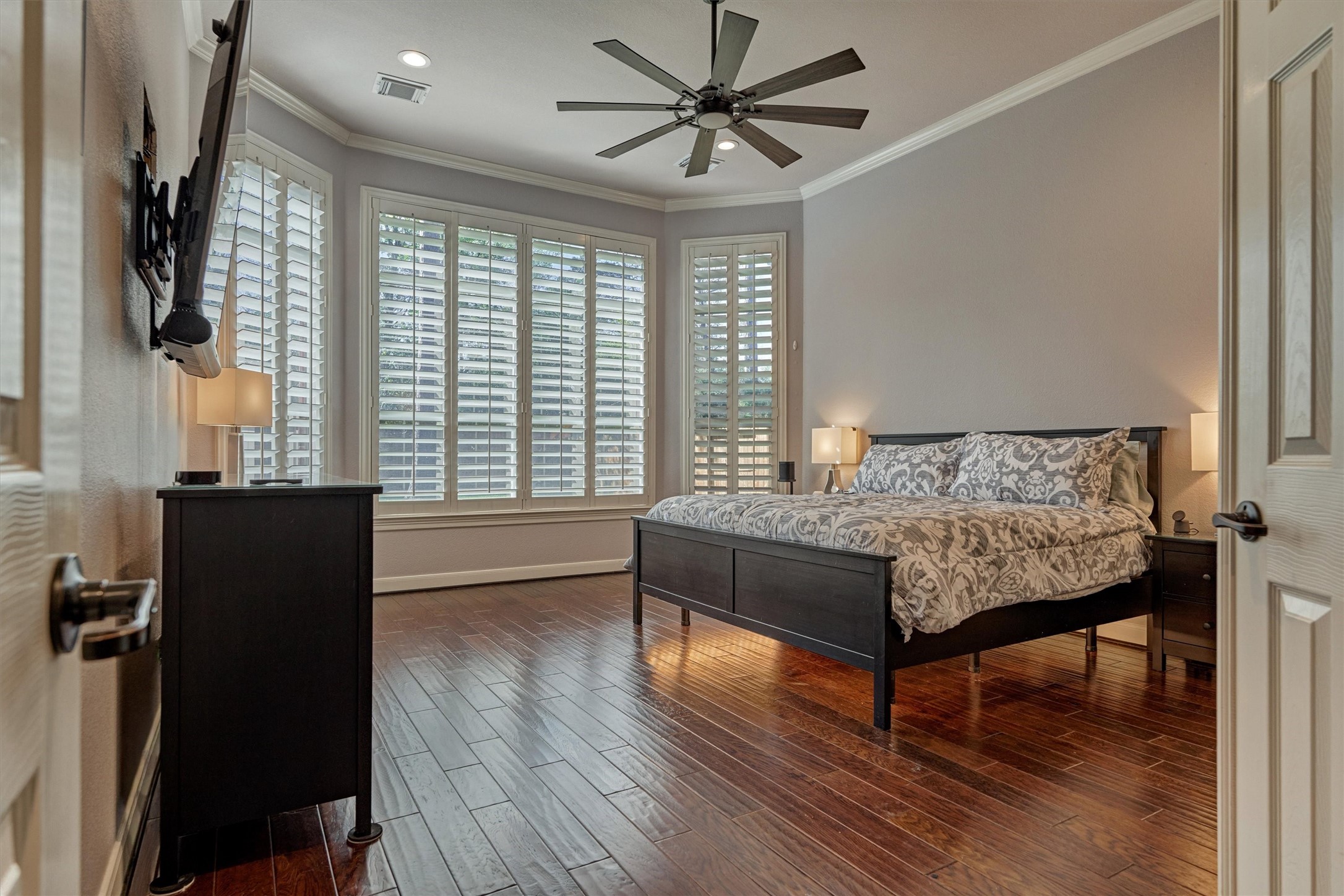6615 Pelham Chase Drive Spring, TX 77389 - Photo 22 of 49 The serene primary bedroom features crown molding, warm wood flooring, and a large bay window overlooking the backyard with custom shutters.