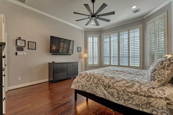 a bedroom with a bed a window and a flat screen television
