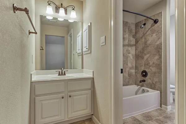 a bathroom with a tub sink and mirror