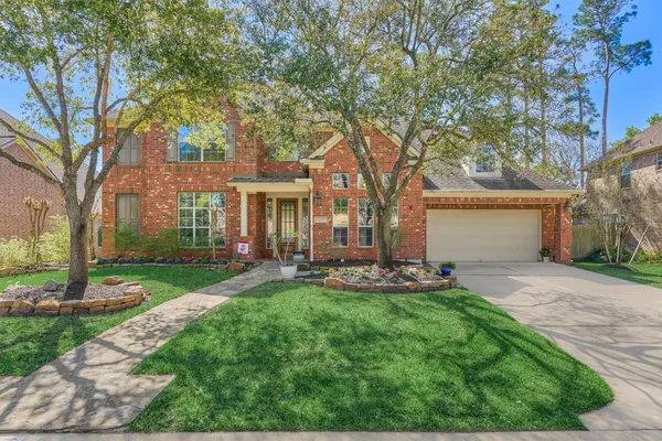 a backyard of a house with table and chairs and a large tree